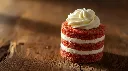 Generate an image of raspberry micro cake cylindrical shape layered topped with piping cream plated in wooden table (1).webp
