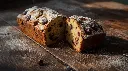 Generate an image of  plum cake loaf in wooden table (1).webp