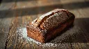 Generate an image of  plum cake loaf in wooden table.webp