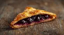 Generate an image of  turnover pastry triangle shape filled with blueberry crush in wooden table.webp