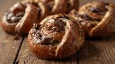Generate an image of chocolate babka braid buns in wooden table (2).webp